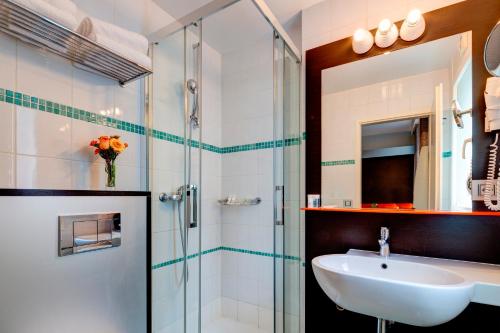a bathroom with a sink and a shower at Design Hotel f6 in Geneva