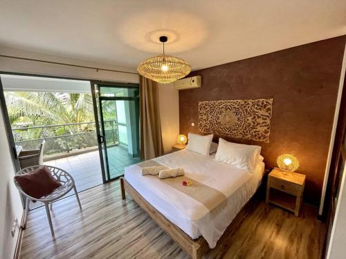 a bedroom with a large bed and a chandelier at City Lodge Appartment in Te Auae