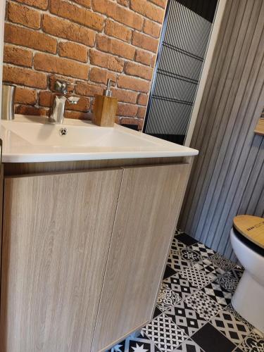 La salle de bains est pourvue d'un lavabo et d'un mur en briques. dans l'établissement Les gorges du Verdon, à Riez