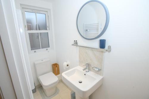 a white bathroom with a sink and a mirror at Cathedral View Rooms in Lincoln