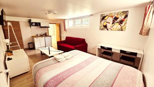 a bedroom with a bed and a red chair at STUDIOS La Varenne Saint Maur entre PARIS ET DISNEYLAND in Saint-Maur-des-Fossés