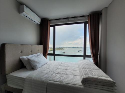 a bedroom with a bed and a large window at Palam Mansion at Apartment One Residence in Batam Center