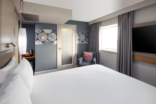a bedroom with a white bed and a chair at Crowne Plaza Harrogate by IHG in Harrogate
