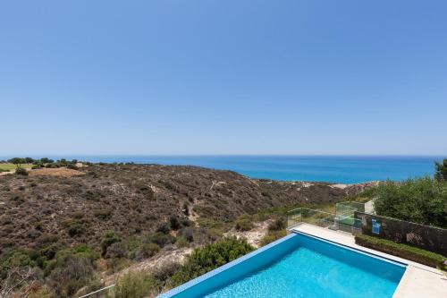 a swimming pool with a view of the ocean at Aphrodite Hills Rentals - Mythos Collection Villas in Kouklia