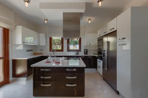 a kitchen with a large center island with a sink at Aphrodite Hills Rentals - Mythos Collection Villas in Kouklia