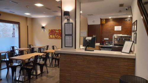 Un restaurante con mesas y sillas y un mostrador. en Hostal Rural Villa Vieja, en Olite