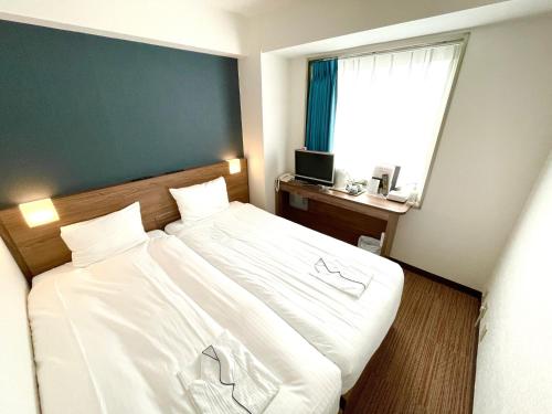 1 dormitorio con 1 cama blanca grande y ventana en Day Nice Hotel Tokyo en Tokio