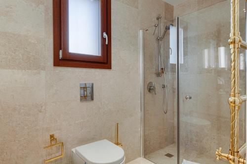 a bathroom with a toilet and a glass shower at Aphrodite Hills Rentals - Mythos Collection Villas in Kouklia