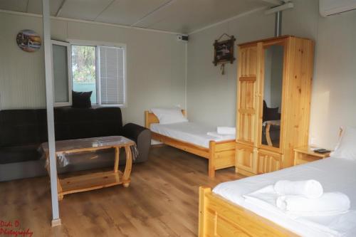 a room with two beds and a black couch at Rich Avdira Beach in Ávdhira