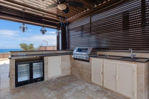 a kitchen with a stove and a counter top at Aphrodite Hills Rentals - Mythos Collection Villas in Kouklia