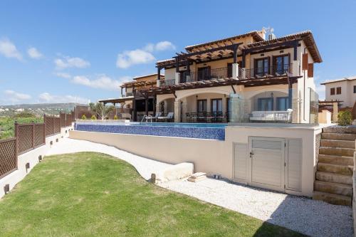 a villa with a swimming pool and a house at Aphrodite Hills Rentals - Mythos in Kouklia