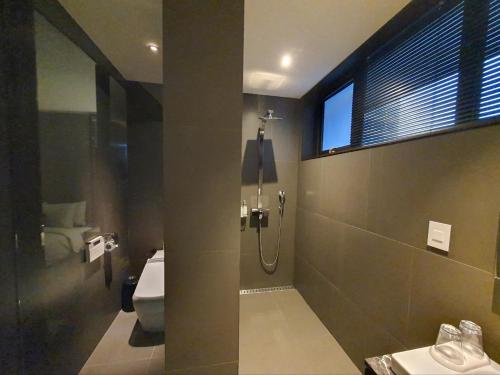 a bathroom with a shower and a toilet and a window at JS Boutique Hotel in Hwaseong