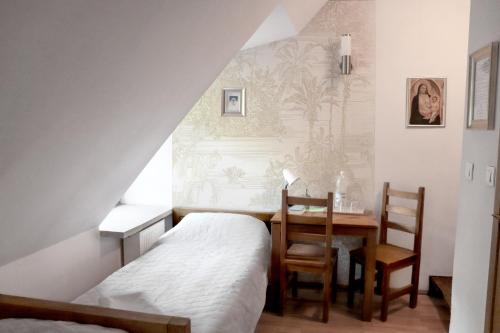 - une chambre avec un lit, un bureau et une table dans l'établissement Karczówka Klasztor, à Kielce