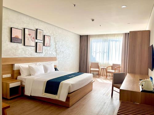 a hotel room with a large bed and a desk at The Hub by Hotel Academy Phu Quoc in Phú Quốc