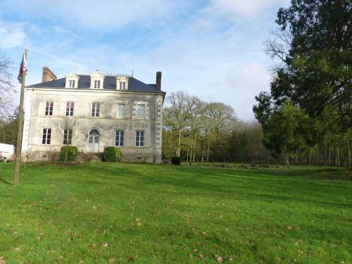 a large white house with a grassy field in front at chateau de Craon in Comblessac