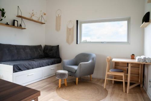 sala de estar con sofá, silla y escritorio en Your own 30sqm house with kitchen, sauna and loft. en Malmö