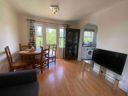 a living room with a dining room table and a television at cosy one bed Mill hill in Hendon