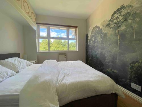 een slaapkamer met een groot bed en een raam bij cosy one bed Mill hill in Hendon