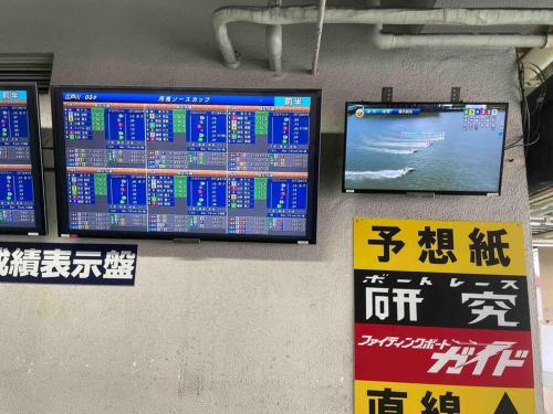 un muro con tre monitor e cartelli di Private Hotel Summer 102 a Tokyo