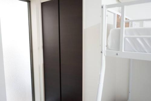 una porta nera in una stanza con finestra di Private Hotel Summer 102 a Tokyo