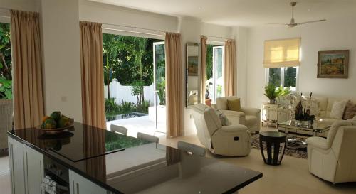 a living room with white furniture and a large window at Las Brisas Villa - Chateau Elysium in Beau Vallon
