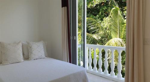 1 dormitorio con cama y ventana grande en Las Brisas Villa - Chateau Elysium, en Beau Vallon