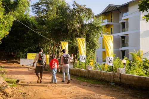 a group of people walking down a dirt road at The Hosteller Gokarna in Gokarna