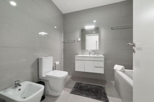 a white bathroom with a toilet and a sink at Palhanas - Holiday Homes - By SCH in Salir de Porto