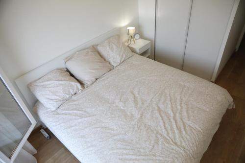a white bed with two pillows on top of it at Le Saint Cyrien in Saint-Cyr-lʼÉcole