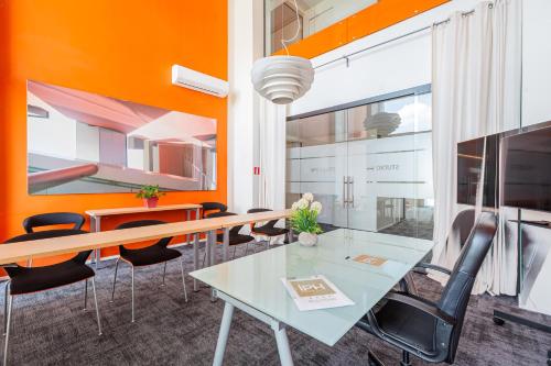 an office with orange walls and a table and chairs at NEW IPOINT HOTEL in San Giovanni in Persiceto