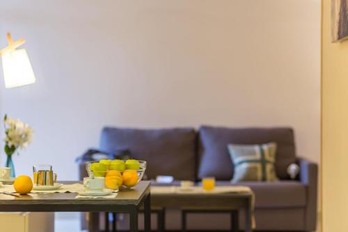 a living room with a couch and a table with fruit on it at Pierre & Vacances Pas de la Casa Princesa in Pas de la Casa