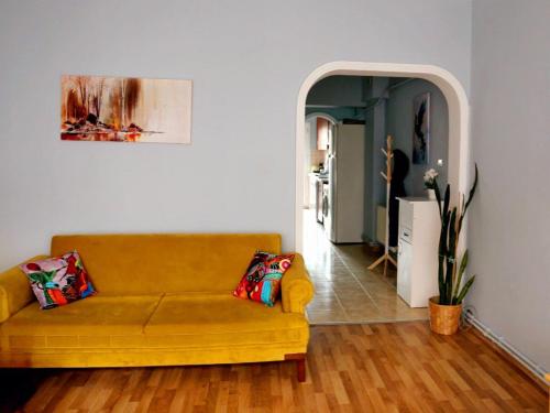 a living room with a yellow couch and a hallway at Kadıköy Yeldeğirmeni'nde daire in Istanbul