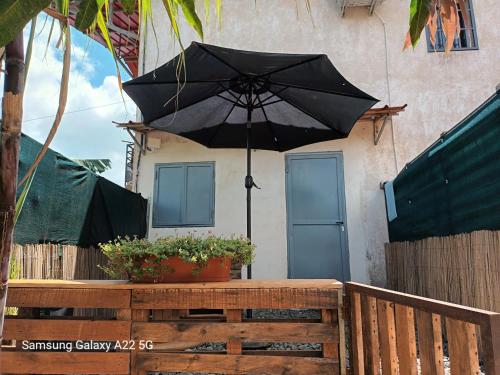 a black umbrella in front of a house at Chez Mkoudou in Ouangani