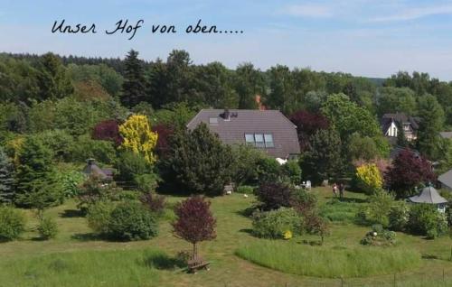 une maison dans un champ planté d'arbres et de buissons dans l'établissement Ferienwohnungen "Christelhof", à Wustrow