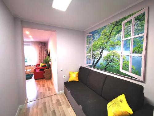 sala de estar con sofá negro y 2 ventanas en Chillout Apart 4You, en Świeradów-Zdrój