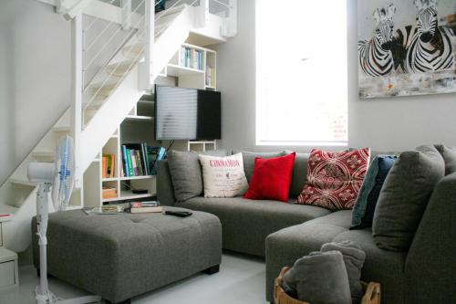 a living room with a couch and a book shelf at Cozy Corner Cottage in Langebaan