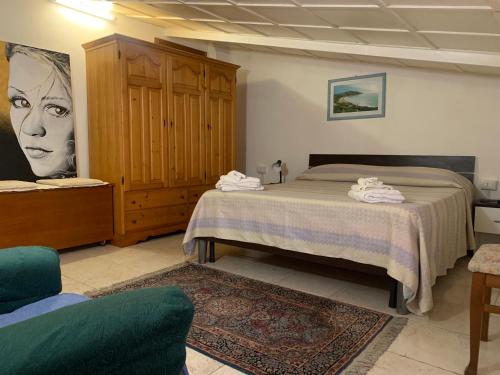 een slaapkamer met een bed, een kast en een bank bij Appartamento con due camere da letto in Quartu SantʼElena