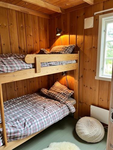 a room with three bunk beds in a cabin at River view in Hovet