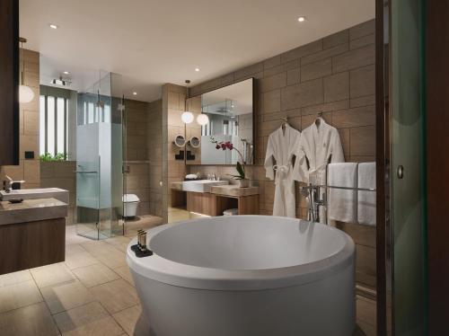 a bathroom with a large tub and a sink at PARKROYAL Langkawi Resort in Pantai Cenang