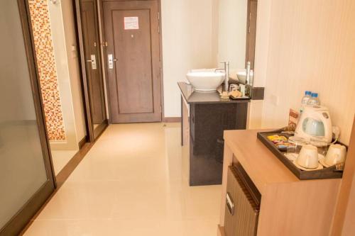 a small bathroom with a sink and a counter with a sink at Chiangmai Grandview Hotel & Convention Center - SHA Extra Plus in Chiang Mai