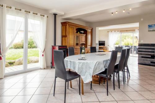 une cuisine et une salle à manger avec une table et des chaises dans l'établissement L’Albizia … Maison familiale proche des plages, à Plougoulm