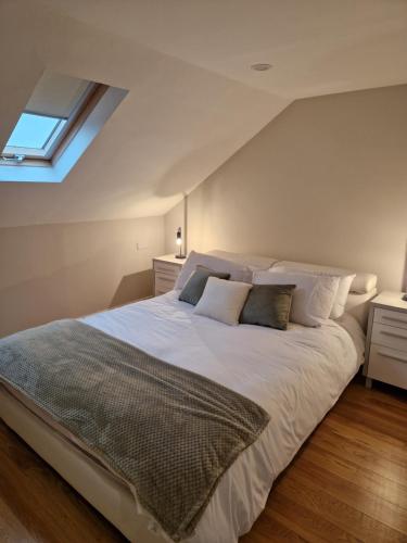 1 dormitorio con 1 cama blanca grande y tragaluz en Erne Annexe, en Lisnaskea