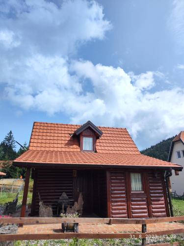 a log cabin with a red tile roof at Vila Carobna suma Tara in Bajina Bašta