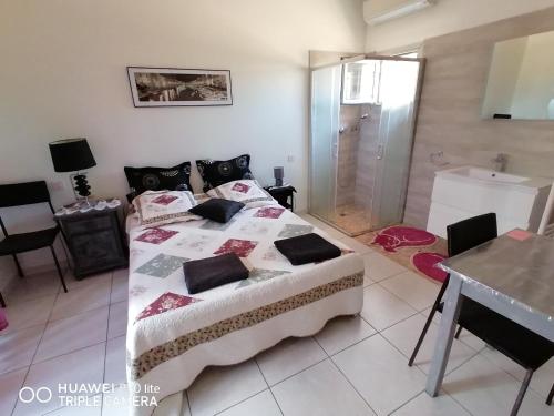 a bedroom with a bed and a table and a bathroom at Grande chambre dans villa proche de la plage in Sète