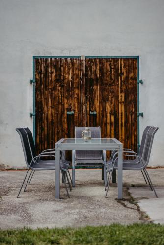 a table and two chairs and a wooden door at Ferienwohnung Morgensonne in Schützen am Gebirge