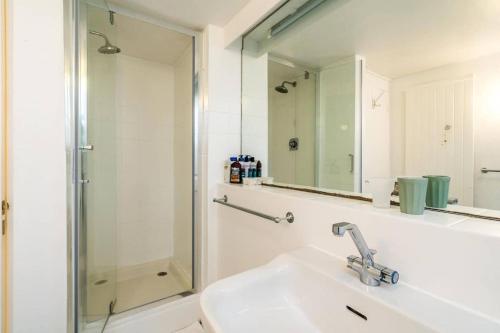 La salle de bains est pourvue d'un lavabo et d'une douche. dans l'établissement Spacious 2 bed Garden Flat by the Thames+parking, à Londres