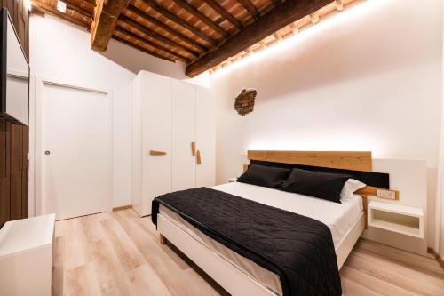 a bedroom with a large bed with white walls and wooden floors at Affittacamere La Rocca Campiglia in Campiglia Marittima