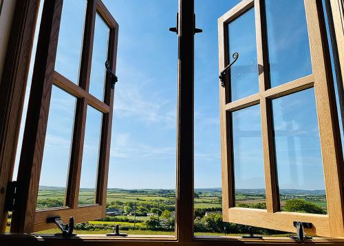 a window with three sinks and a view of the countryside at Beacon Country House Hotel & Luxury Shepherd Huts in St. Agnes 