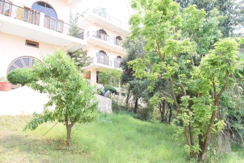 a building with trees in front of it at Himalaya Mount View Resort Kausani in Kausani