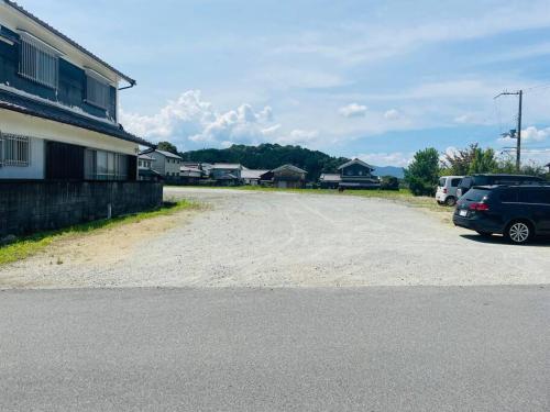 un estacionamiento con un coche estacionado al lado de una casa en えん飛鳥　日本始まりの地　古民家一棟貸し　8人＋大型犬も宿泊可能, en Asuka